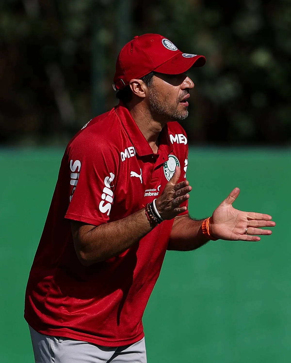 O técnico Abel Ferreira, de boné vermelho, orienta os jogadores durante treino na Academia de Futebol.